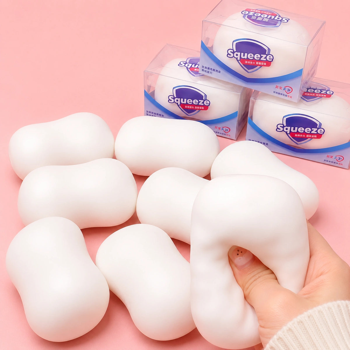 Soft white soap-shaped squishy stress relief toys with a hand squeeze demonstration and retail packaging.