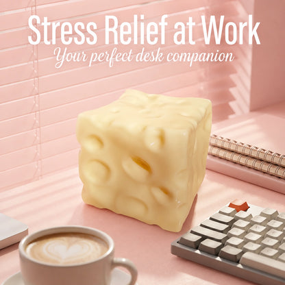 Cheese squishy desk stress relief toy beside a keyboard and coffee cup