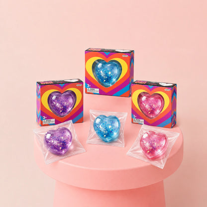 Pink, purple and blue glitter heart squishy stress relief toys with colorful retail packaging, perfect for squeezing, fidgeting and gifts.